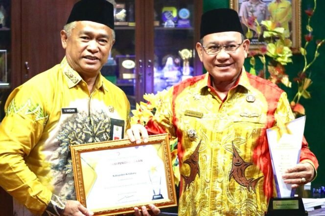 
 Bupati Kotabaru H Sayed Jafar bersama Kepala Dinas Koperindag H Hardani menerima penghargaan.