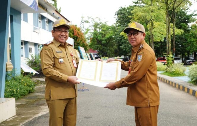 
 Sekda Banjar HM Hilman menyerahkan dokumen perjanjian kinerja 2025, Senin (24/2/2025). foto-RSB