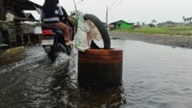 Jalan rusak berlobang dipasang drum di tengah banjir di Kampung Melayu Ilir, Martapura Timur, Kabupaten Banjar. foto-haris 