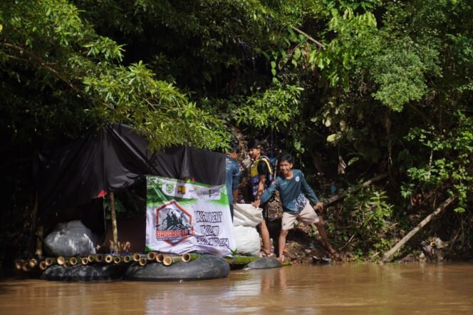 
 Peserta sedang memungut sampah di bantaran sungai saat pengarungan. Foto: WAN