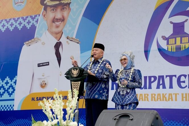 
 Gubernur Kalsel H Muhidin saat menyampaikan pidato didampingi istrinya Hj Fathul Jannah, di puncak Harjad 75 Kabupaten Banjar, di Martapura, Rabu (27/8/2025). Foto: Agus Fahlepi/MC Kominfo for Riceknews.