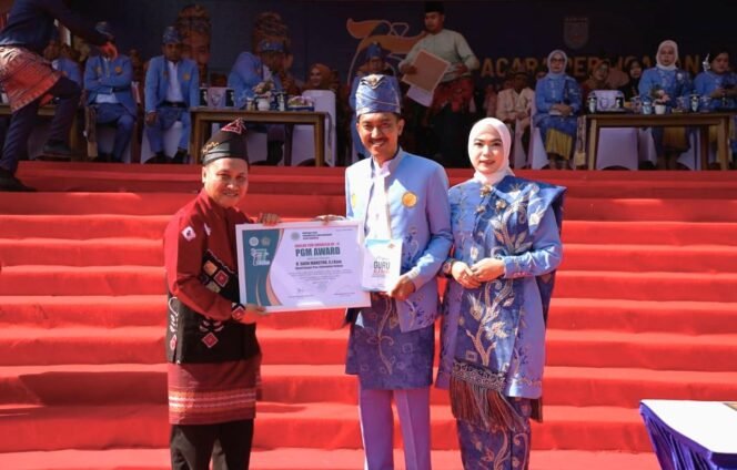 
 Bupati Banjar H Saidi Mansyur didampingi istri saat menerima penghargaan PGM Award dari Pengurus Pusat Perkumpulan Guru Madrasah (PGM) Indonesia, Kamis (14/8/2025). Foto: MC Kominfo Banjar