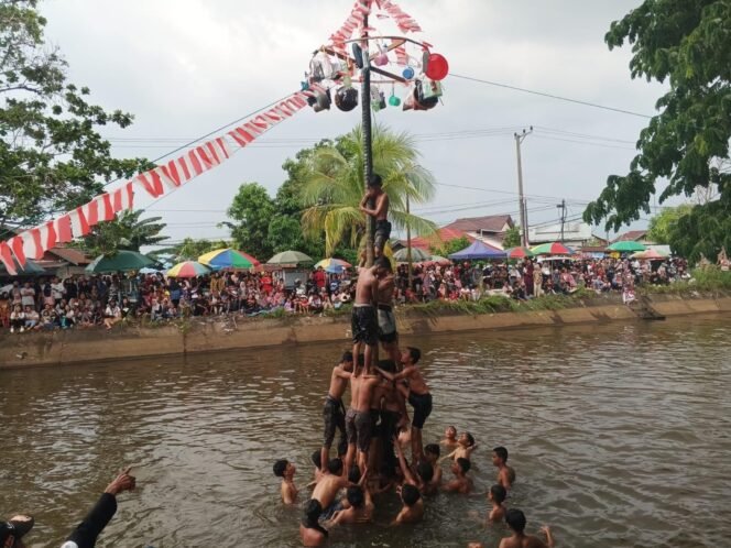 
 Panjat Pinang di irigasi Martapura, Kabupaten Banjar, Sabtu (23/8/2025). Foto: Haris