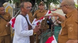 Kesbangpol Kotabaru saat membagikan bendera merah putih kepada masyarakat, Selasa (5/8/2025). Foto: istimewa