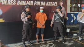 Tersangka A saat dikawal petugas dalam Press Conference di Polres Banjar Kalsel, Senin (22/12/2025). Foto: Ofal Ricek.ID 