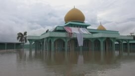 Terlihat seorang dari beberapa warga yang mengungsi di atap Masjid gegara banjir. foto: ricek.id