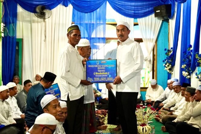 
 Bupati Banjar H Saidi Mansyur menyerahkan secara simbolis bantuan hibah kepada sejumlah yayasan keagamaan dalam Safari Ramadan perdana di Masjid Jami Darul Muhajirin, Desa Munggu Raya, Kecamatan Astambul, Kamis (19/2/2026) sore. Foto: RSB