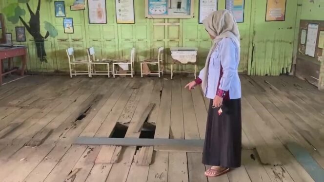 
 Kepala SDN Jawa Laut 1, Andrianci MH menunjukkan salah satu ruang kelas yang mengalami kerusakan.